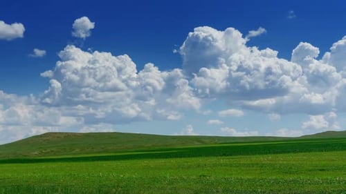 Green Hill with Grass Under Clouds
