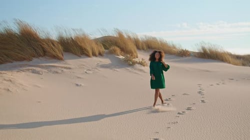 Girl Jogging Down Sand Hill Leaving Footprints on Desert