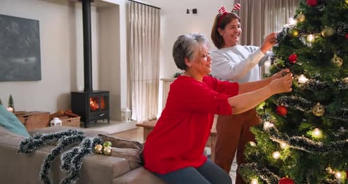 Senior Women Decorating Christmas Tree with Joy
