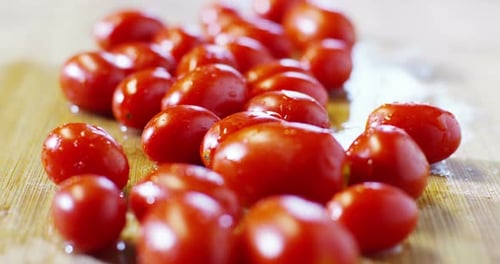 fly macro on pizza and pasta ingredients on wooden cutting board , cherry tomatoes and piccadilly