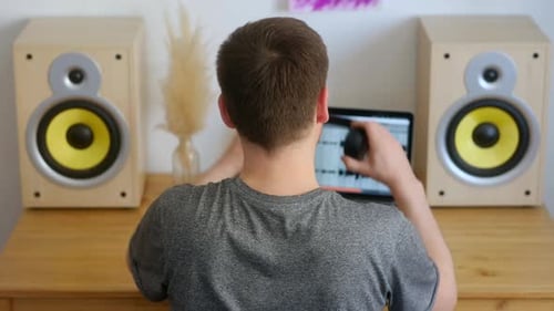 Young Adult Puts on Headphones in Studio