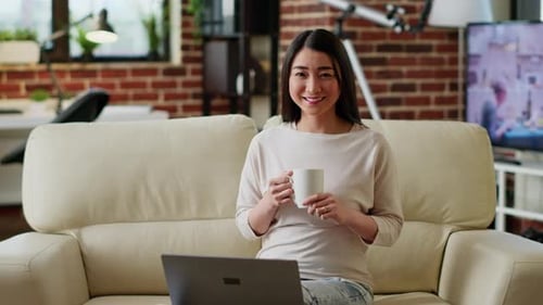 Woman Smiling With Laptop and Coffee at Home