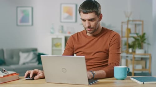 Man Using Laptop at Desk in Home Office