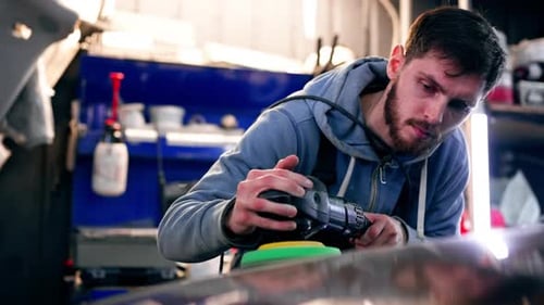 the Car Mechanic at a Service Station Doing the Final Polishing to Shine