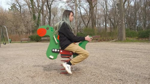 Girl Ride the Carousel on Empty Playground