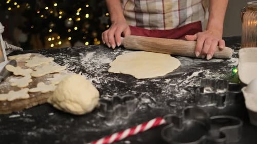 Woman Rolling Dough for Christmas Cookies at Home