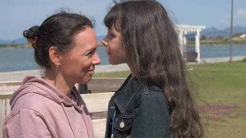 Loving Mother and Daughter Embrace by the Water