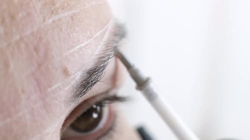 Detailed View of a Professional Conducting Eyebrow Mapping on a Woman for Permanent Makeup