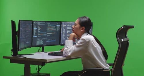 Tired Woman Developer Yawning While Write Code With Multiple Screens In Green Screen Studio