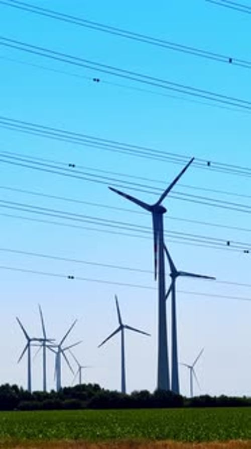 Wind Turbines Rotating in a Field on a Sunny Day