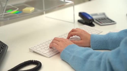 Office Worker Typing on White Keyboard