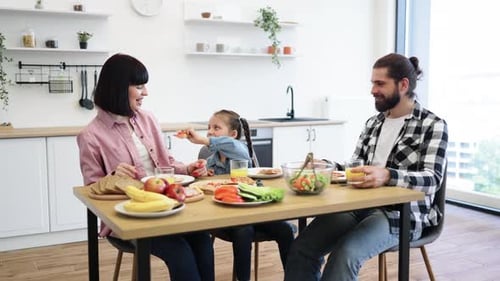 Family Eating Pizza Together at Kitchen Table