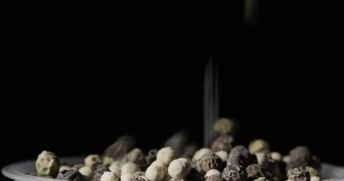Colorful Peppercorns Falling into Bowl in Slow Motion