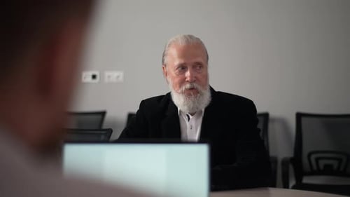 Tracking Shot Portrait of Serious Mature Adult Male Team Leader in Suit Talking to Colleagues on