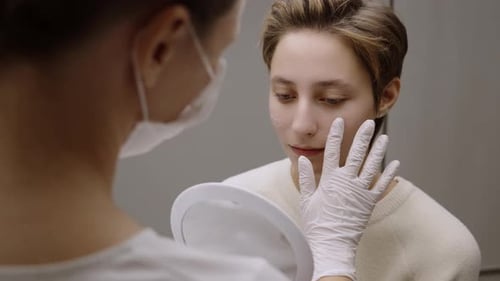 Eine Frau konsultiert nach einer plastischen Gesichtschirurgie einen Arzt
