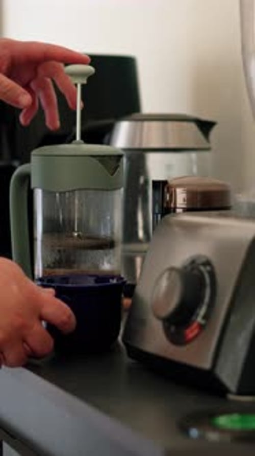 Vertical video man pushes down plunger on french press, Home making fresh coffee