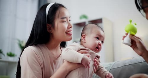 Woman Holding Baby with Toy Indoors