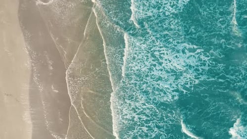 Drone aerial view of paradise beach. Turquoise sea water and clear sand at sunset.