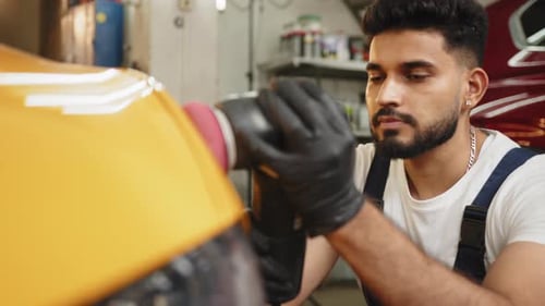Man Polishing Yellow Car in Garage