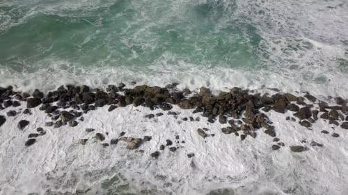 Waves Crashing on Rocky Shore from Above