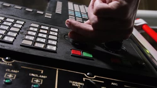 Engineer Hand Turns Round Handles on Control Panel at Plant