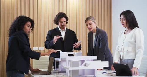 Architect shares detailed building plans with colleagues in a design meeting