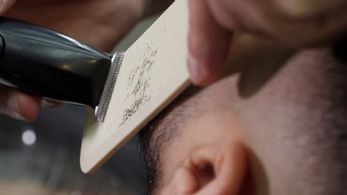 Barber Trimming Hair with Razor and Comb Close-up