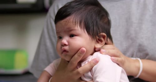 Loving Adult Holding Infant Close Indoors