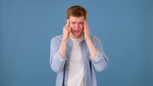 Sick Guy Touching Head and Massaging Temples in Studio