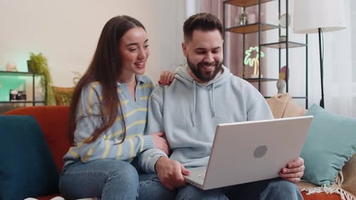 Couple Video Chatting with Friends on Laptop at Home