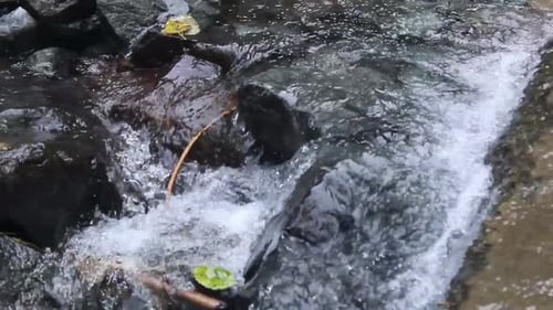 A shot following a river as it flows over rocks of various shapes and textures.