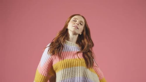 Portrait of a Redhaired Model in a Pullover on an Isolated Background a Woman Posing for the Camera