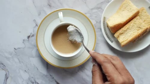 Top View of Putting Sugar in a Tea Cup