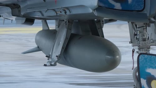 Missile Attached Underneath an Aircraft Wing on Tarmac
