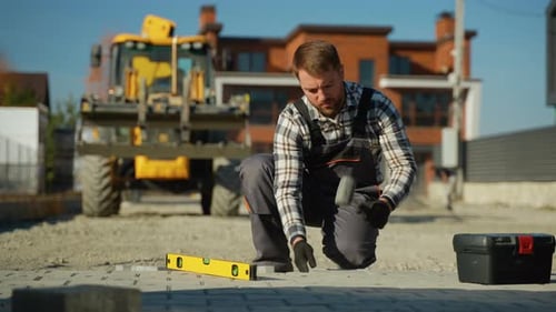 Adult Laying Paving Stones on Suburban Walkway