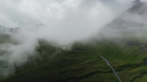 Winding Road Through Misty Green Mountain Landscape