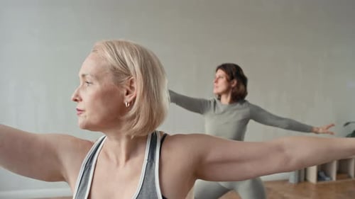 Women Practicing Yoga Poses in a Bright Room