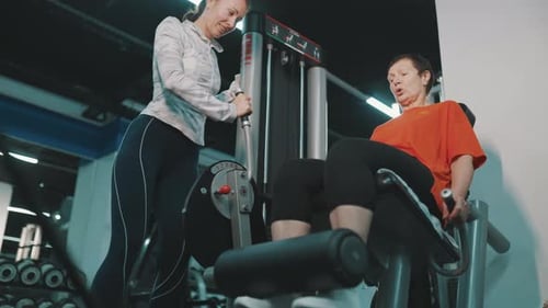Personal Trainer ajudando mulher sênior com exercícios para as pernas