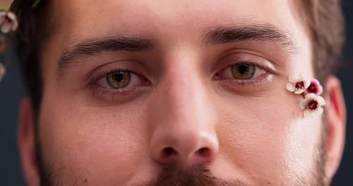 Flowers, self confidence and beauty with eyes of man in studio for acceptance, natural and pride