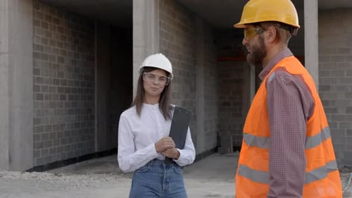 Construction workers inspecting building site progress, architect and foreman discussing project