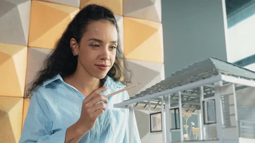 Engineer holding house model while inspect building construction. Manipulator.