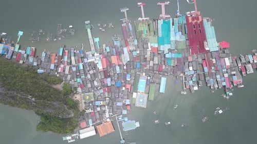 Die Luftaufnahme von oben nach unten zeigt die Dächer eines Dorfes in der Gegend von Phang-Nga in Thailand in der Nähe eines Hügels