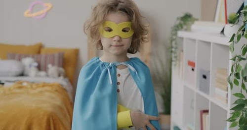 Child in Cape and Mask Standing in Bedroom