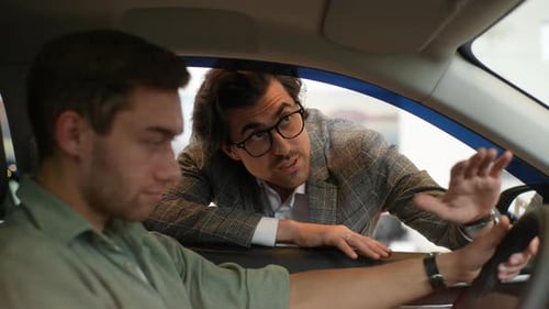 Closeup View Through Side Window From Interior of Car to Auto Dealer in Business Suit Talking to