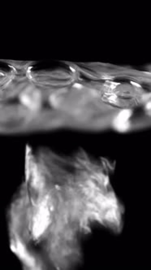 Boiling Water Bubbles Rise Up Closeup on Black Background Vertical