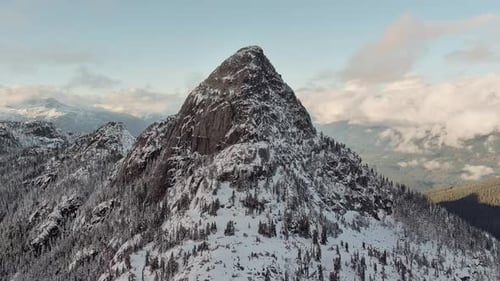 Rocky Mountain Peak Covered in Snow Dramatic Cloudy Sunset Aerial British Columbia Canada