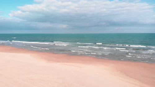 Wide empty sandy beach with turquoise sea waves in Costa Blanca, Spain
