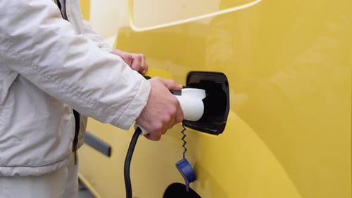 Male Hand Disconnects Power Connector Into EV Car