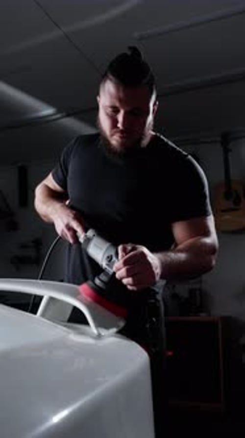 Un hombre está puliendo un coche con una pulidora