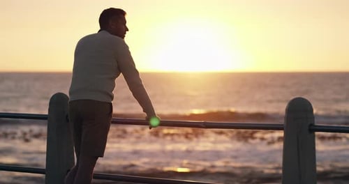 Depression, anxiety or sad man by sea, ocean or beach thinking of memory at sunset